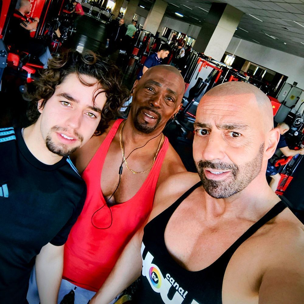 entrenadores personales con alumno en gimnasio